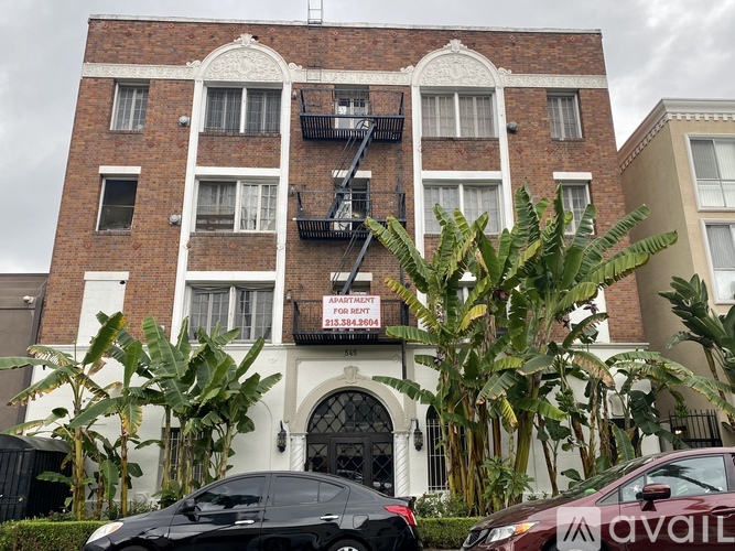 A building with a sign that says "available for rent" in front of it.