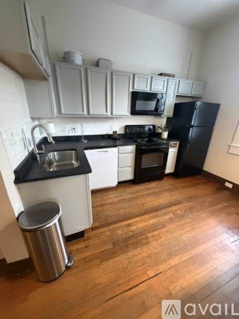 A kitchen with black countertops and white cabinets.