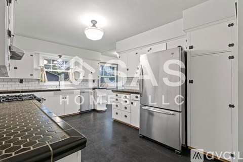 A modern kitchen with stainless steel appliances and a black countertop.