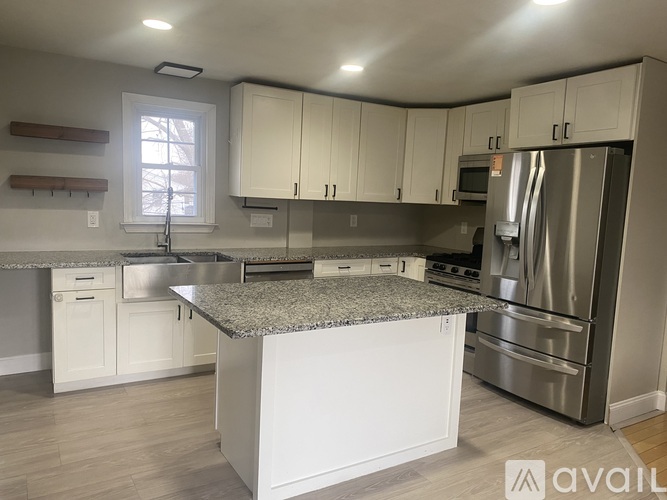 A kitchen with white cabinets and a granite countertop.