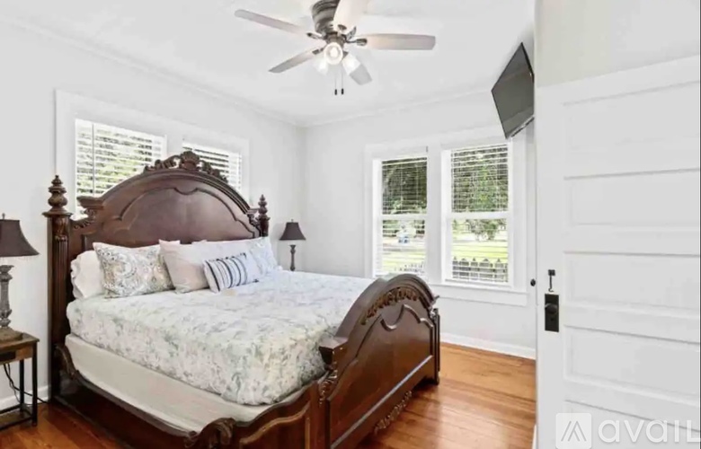 A bedroom with a large bed and a ceiling fan.