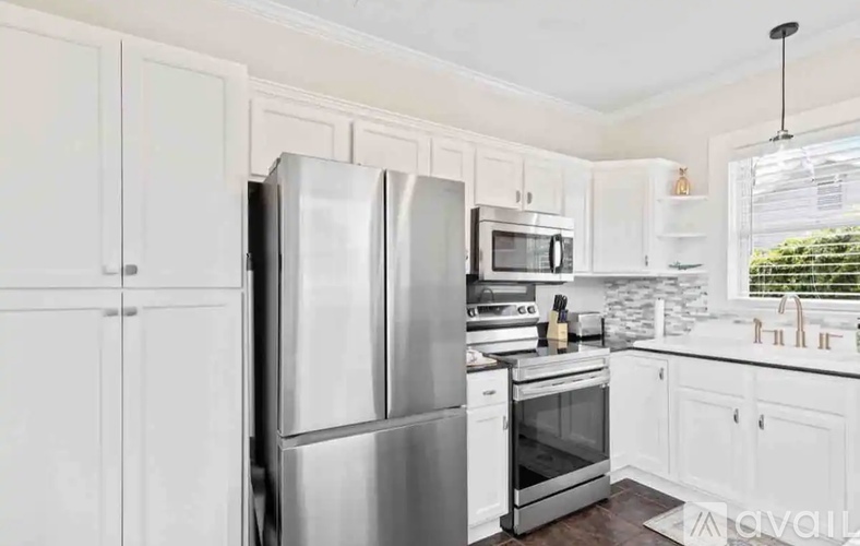 A kitchen with white cabinets and stainless steel appliances.