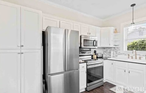 A kitchen with white cabinets and stainless steel appliances.