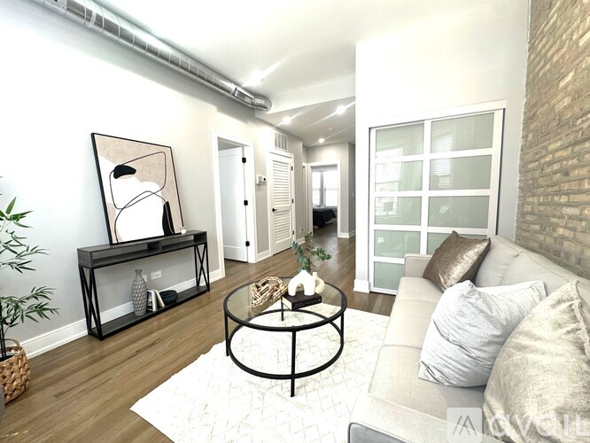 A living room with a glass table and a white couch.