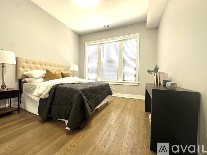 A bedroom with a large bed and a wooden floor.