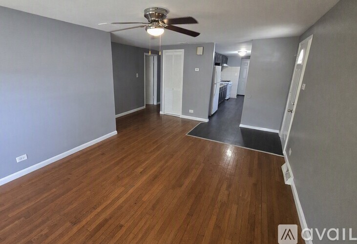 A room with wooden flooring and a ceiling fan.