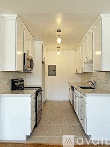 A kitchen with white cabinets and appliances.