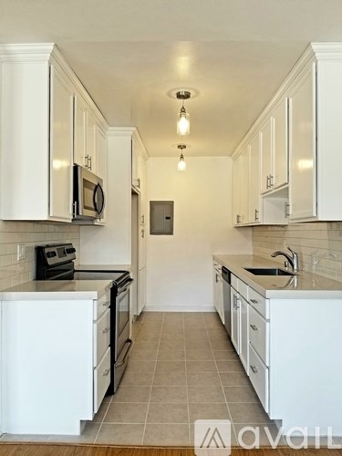 A kitchen with white cabinets and appliances.