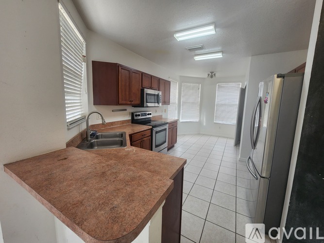 A kitchen with brown countertops and white appliances.