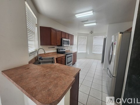 A kitchen with brown countertops and white appliances.