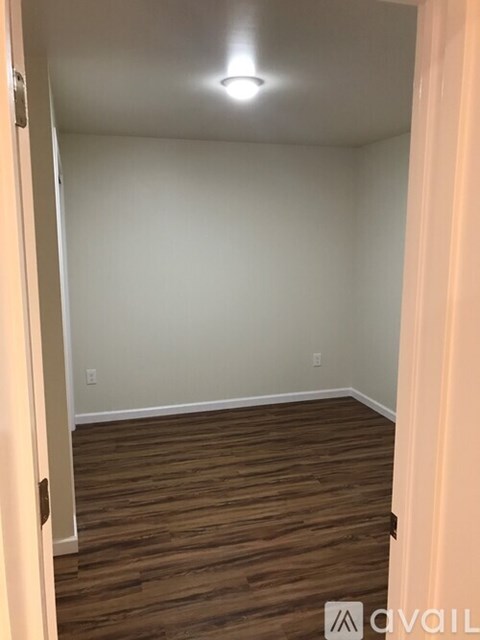 A room with wooden flooring and white walls.