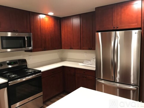 A kitchen with wooden cabinets and stainless steel appliances.