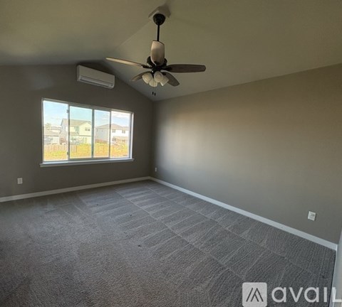 A room with a ceiling fan and carpeted floor.