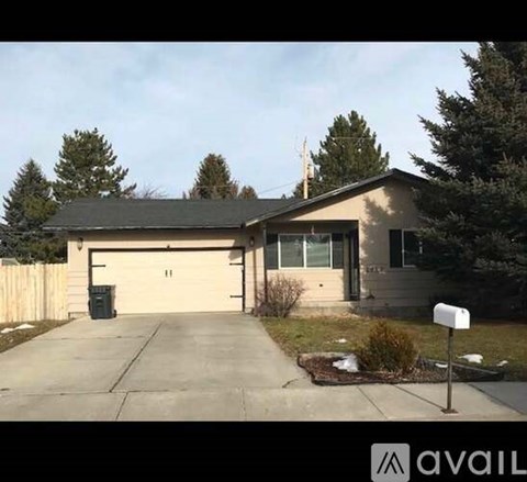 A house with a garage and a mailbox in front.