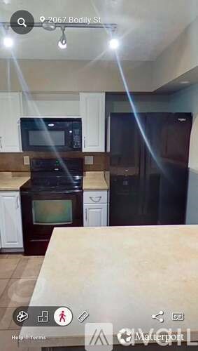 A kitchen with a microwave, oven, and refrigerator.