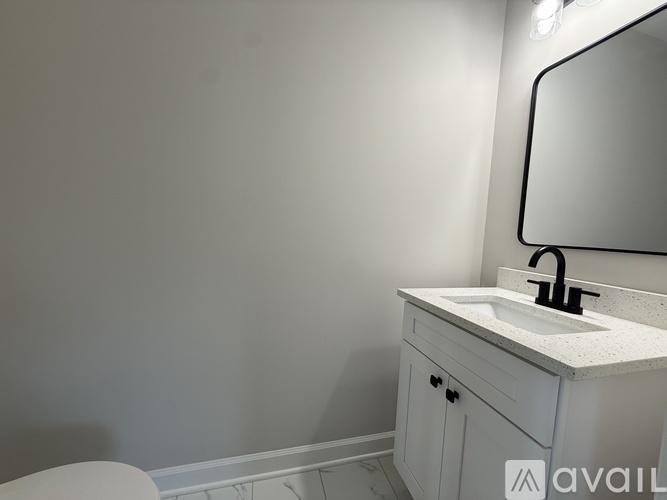 A bathroom with a sink, mirror, and toilet.