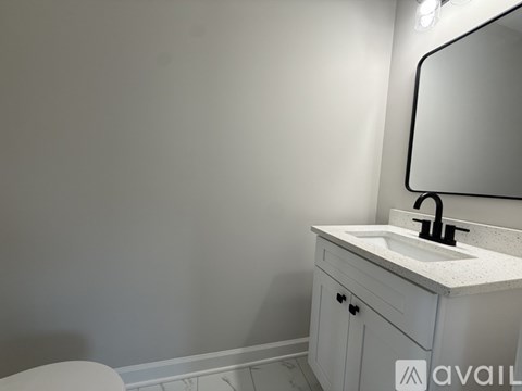 A bathroom with a sink, mirror, and toilet.