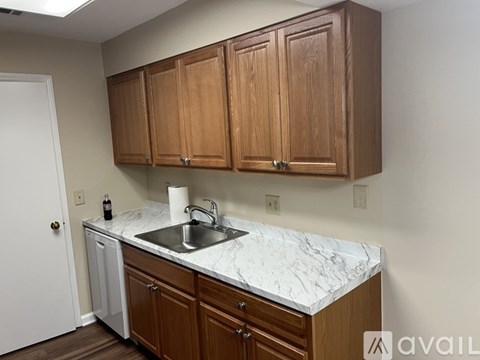 A kitchen with wooden cabinets and a marble countertop.