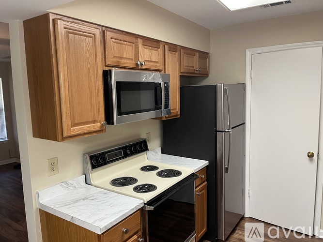A kitchen with a stove, microwave, and refrigerator.