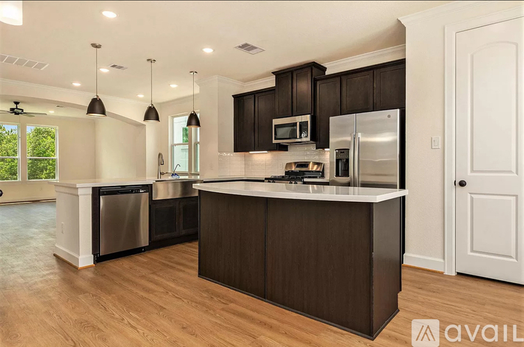 A kitchen with dark wood cabinets and stainless steel appliances.