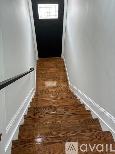 A long flight of wooden stairs leads to a door at the top.
