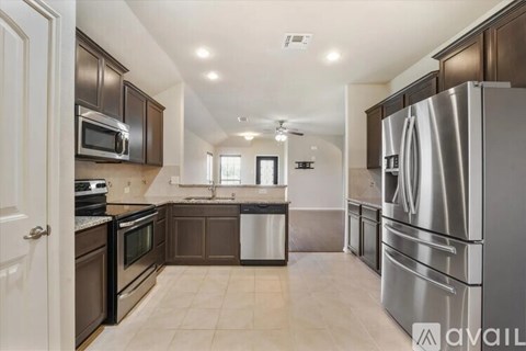 A kitchen with a refrigerator on the right side.