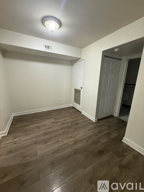 A room with wooden flooring and a white ceiling light.