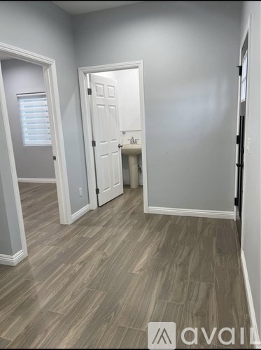 A room with a white door and a wooden floor.