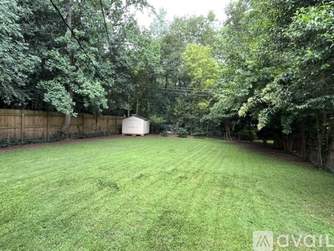 A backyard with a fence and trees.