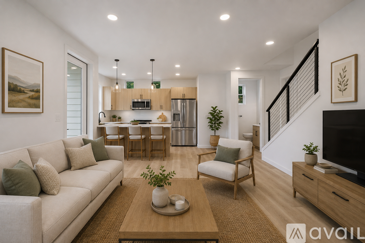 A well-lit, modern living room with a staircase leading to the upper floor.