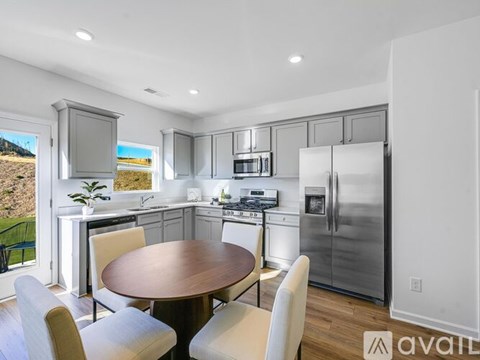 A modern kitchen with a dining table and chairs.
