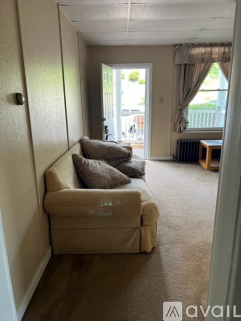 A living room with a couch and a window.