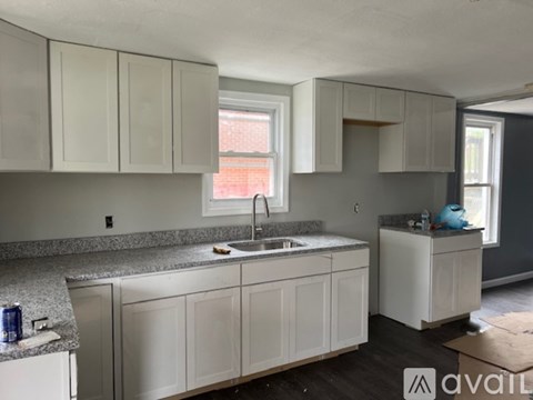A kitchen with white cabinets and a granite countertop.