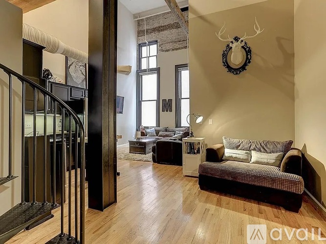 A living room with a couch, a coffee table, and a deer head on the wall.