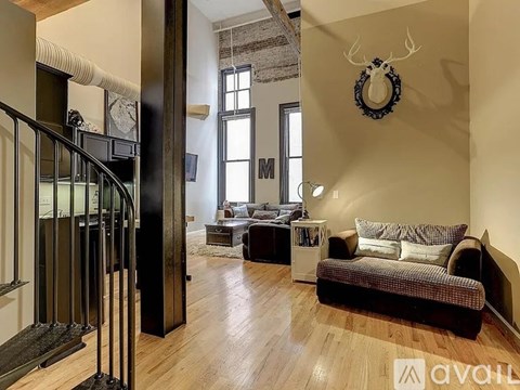 A living room with a couch, a coffee table, and a deer head on the wall.