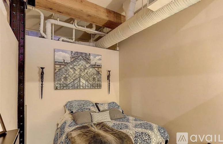 A bedroom with a bed and a picture on the wall.
