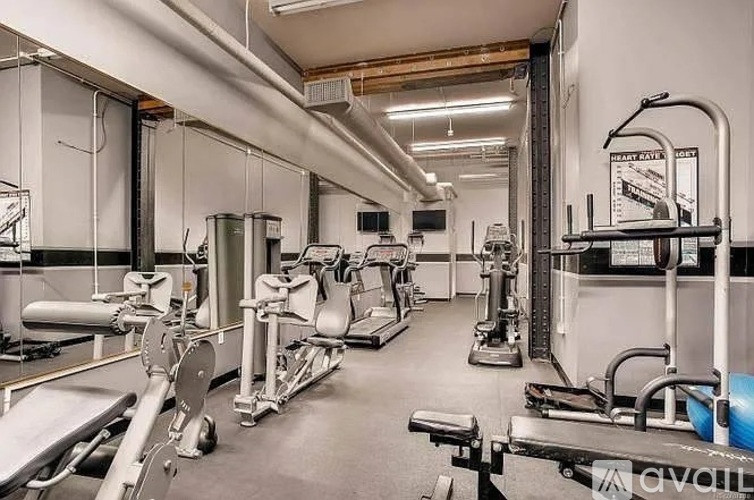 A gym with a variety of equipment including treadmills, weights, and exercise machines.