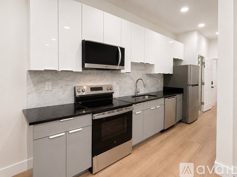 A modern kitchen with stainless steel appliances and white cabinets.