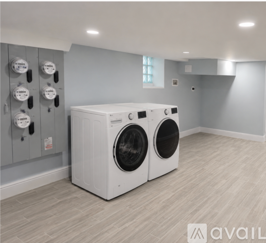 A washing machine in a laundry room with a grey wall.