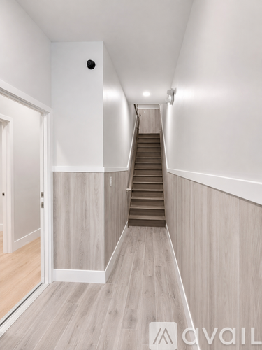 A hallway with a staircase and a door on the left.