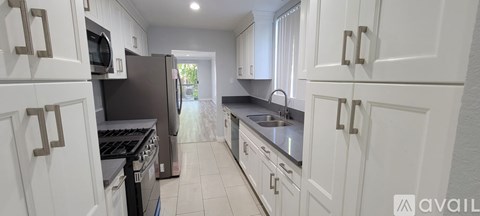 A kitchen with white cabinets and a black stove top oven.