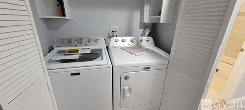 A small laundry room with a washer and dryer.