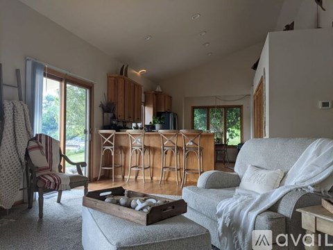 A living room with a grey couch and wooden furniture.