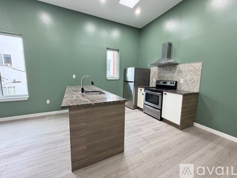 A kitchen with green walls and a wooden island.
