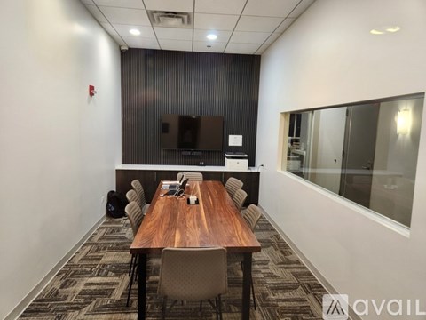A conference room with a long table and chairs.