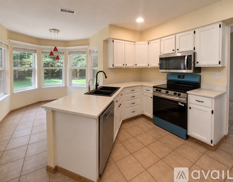 A kitchen with white cabinets and a large island.