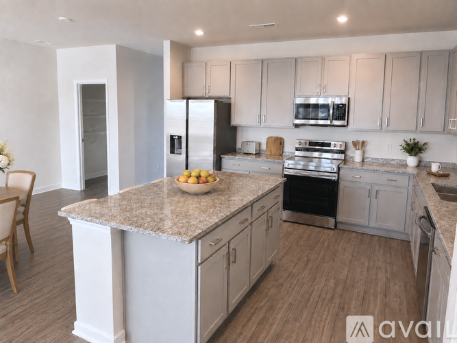 A kitchen with a granite countertop and stainless steel appliances.