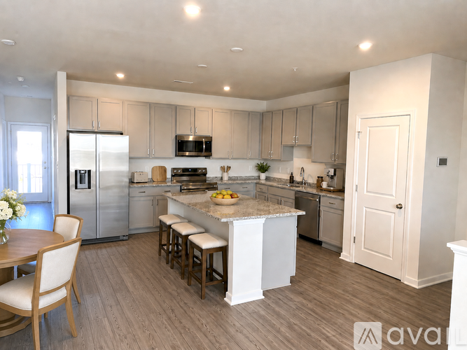 A kitchen with a table and chairs in front of it.