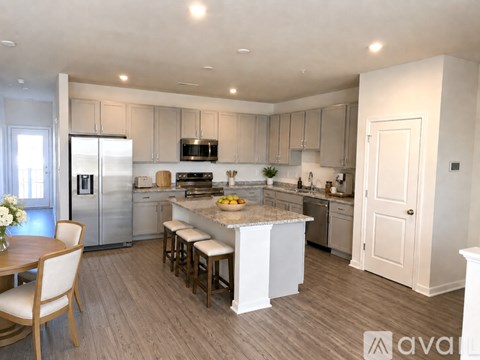 A kitchen with a table and chairs in front of it.