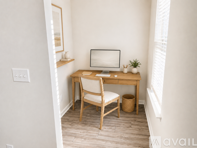 A small desk with a chair and a computer monitor in a corner of a room.